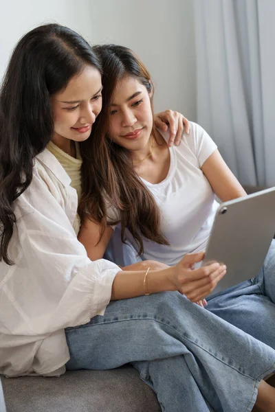Koncepcja lgbtq lub lgbt, homoseksualizm, dwie azjatyckie kobiety cieszące się razem i okazujące sobie miłość podczas używania tabletu — Zdjęcie stockowe