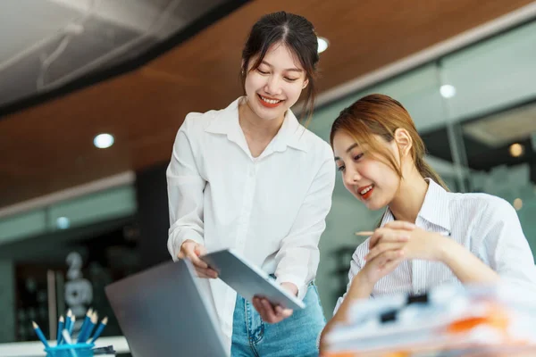 Negotiation, Analysis, Discussion, Portrait of an Asian woman economist and marketer using tablet computer to plan investments and financial to prevent risks and losses for the company.