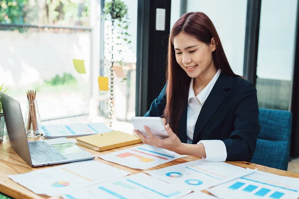 financial, Planning, Marketing and Accounting, portrait of Asian woman Economist using calculator to calculate investment documents with partners on profit taking to compete with other companies.