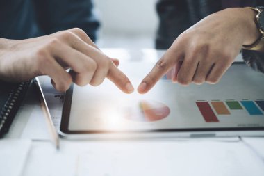 Müzakere, Analiz, Tartışma, Asyalı genç ekonomist ve pazarlamacı, yatırım planlamak için tablet bilgisayar ve şirket için risk ve zararları önlemek için mali kaynak kullanıyor.