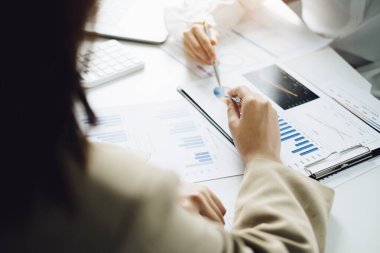 Beyin Fırtınası, Danışmanlık, Veri Analizi, Planlama, Pazarlama ve Muhasebe, Ekonomist, Yatırım belgelerine işaret eden bir kalem tutuyor.