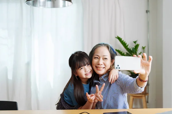 Ασιατικό Πορτρέτο Γιαγιά Και Εγγονή Κάνουν Ψυχαγωγικές Δραστηριότητες Χρησιμοποιώντας Τηλέφωνά — Φωτογραφία Αρχείου
