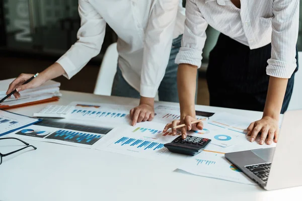 financial, Planning, Marketing and Accounting, Asian woman Economist using calculator to calculate investment documents with partners on profit taking to compete with other companies.