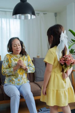 Asyalı portre, büyükanne ve torun boş zaman aktiviteleri yapıyor ve birbirlerine sevgilerini ve ilgilerini göstermek için sarılıyorlar..