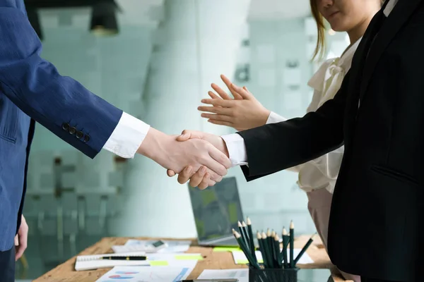 Asian entrepreneurs handshakes to congratulate the agreement between the two companies to enhance investment and financial strength. deal concept.