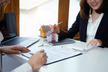 Teminat, mortgage, sözleşme, sözleşme, imzalı, emlakçı veya banka memuru hesap makinesini işaret ederek, anlaşma imzalamadan önce bir ev satın almak için müşteriye teklif sunar..