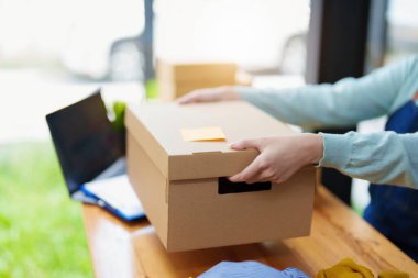 Bir iş kadınının portresi, paketlenmiş ürünleri kutulara koyuyor ve müşterilere siparişlerine göre dağıtım yapıyor..