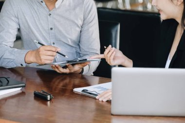 Takım çalışması konsepti, danışmanlık, erkek ekonomist elinde bütçe, finans ve yatırım belgelerine işaret eden, konferans odasında kadın danışmanlarla finansman görüşmeleri ve planlama