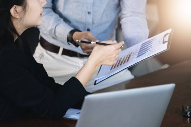 Takım çalışması konsepti, danışmanlık, kadın danışman bütçeye, finans ve yatırım belgelerine işaret ederek, konferans odasında erkek ekonomistlerle finansman görüşmeleri ve planlama
