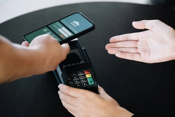 Payment security technology concept and service fees, Employees are holding electronic card machines for customers to use smartphone mobile to pay via paywave technology
