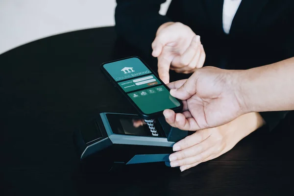 Payment security technology concept and service fees, Employees are holding electronic card machines for customers to use smartphone mobile to pay via paywave technology