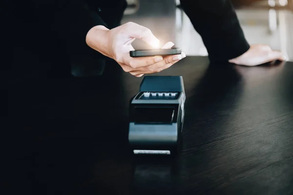 Secure payment technology concept and service charge, customers are using their phone to pay using paywave technology by tapping near the electronic card terminal