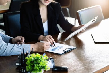 Takım çalışması konsepti, danışmanlık, erkek ekonomist elinde bütçe, finans ve yatırım belgelerine işaret eden, konferans odasında kadın danışmanlarla finansman görüşmeleri ve planlama