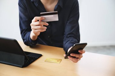 Çevrimiçi ödeme, Genç Kadınlar kredi kartı ve online alışveriş için akıllı telefon kullanıyor.