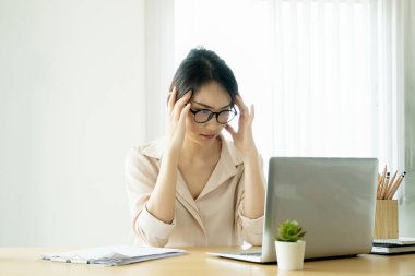 Yeni normal, bir iş kadını bir şirkette çalışmak için bilgisayar kullanıyor evdeki masandaki internet üzerinden..