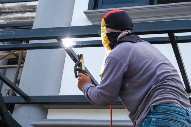 Kaynakçı eve eklemek için çelik yapıyı kaynaklıyor.