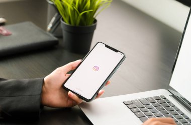 CHIANG MAI, THAILAND - 06 Nisan 2021: Instagram uygulamasının giriş ekranı ile iPhone 'u tutan bir kadın. Instagram en büyük ve en popüler sosyal ağdır.