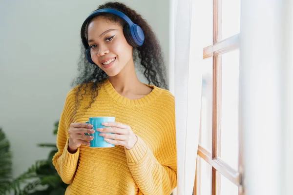 Afroamerykanin Noszący Słuchawki Trzymający Kubki Kawy Uśmiechający Się Szczęśliwie Podczas — Zdjęcie stockowe