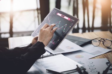 Borsada hisse senedi satarak kar elde etme konsepti, kadın ayak işleri, çalışmak için tablet kullanarak borsada kar elde etmenin amacını analiz ediyor.