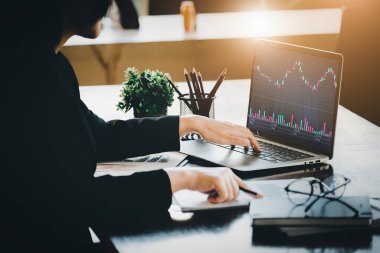 Finansal ve yatırım planlama konsepti, kadın iş kadınının bir ticaret kurulunda giriş noktaları bulmak için haritaları analiz etmek için bilgisayarını kullanması. İnternet üzerinden dijital ortamda