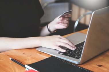 Çevrimiçi alışveriş için bilgisayar ve kredi kartı kullanan genç kadınlarla çevrimiçi ödeme.