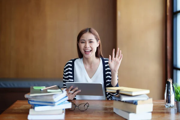 在图书馆举行的网上视频会议课上 一个面带微笑的年轻亚洲女人用平板电脑的肖像 — 图库照片