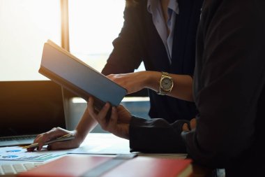 İş danışmanları istatistik grafiklerini ve bu çeyrekte karı artırmanın yollarını anlatan bir defter kullanıyorlar..