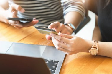 Çevrimiçi alışveriş için akıllı telefon ve bilgisayar kullanan erkeklerle konuşurken kredi kartı kullanmayı tercih edin