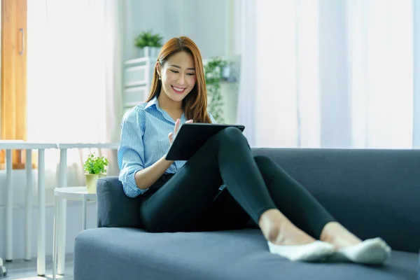 网上学习 网上购物 信息搜索 年轻的亚洲女人用平板电脑在家里工作 — 图库照片