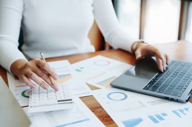 Muhasebeciler ve Asyalı denetçiler vergi bütçelerini gözden geçirmek için hesap makineleri ve bilgisayarlar kullanarak vergi dairesine bilgi gönderiyorlar.