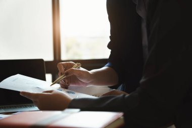 Şirket çalışanı bütçeyi hesaplamak ve yatırımın doğruluğunu doğrulamak için belgeyi işaret ediyor