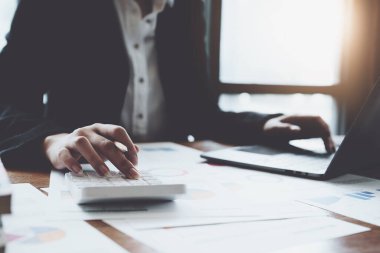Muhasebeciler ve Asyalı denetçiler vergi bütçelerini gözden geçirmek için hesap makineleri ve bilgisayarlar kullanarak vergi dairesine bilgi gönderiyorlar.