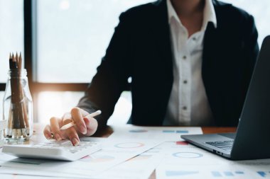 Muhasebeciler ve Asyalı denetçiler vergi bütçelerini gözden geçirmek için hesap makineleri ve bilgisayarlar kullanarak vergi dairesine bilgi gönderiyorlar.