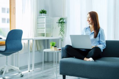 İnternet eğitimi, çevrimiçi alışveriş, satış, toplantı, bilgi araması, evde çalışmak için tablet kullanırken gülümseyen genç Asyalı kadının portresi