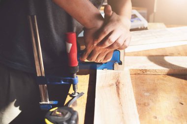 Entrepreneur Woodwork holding a Tacker to assemble the wood pieces as the customer ordered