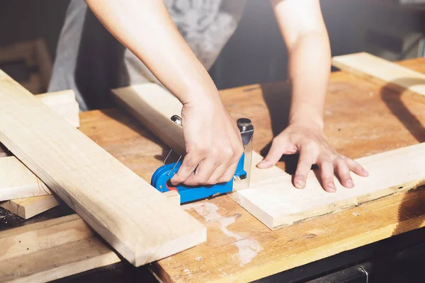 Girişimci Woodwork, müşterinin emrettiği gibi tahta parçaları birleştirmek için bir raptiye tutuyor.