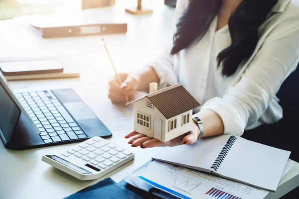 Entrepreneurs, business owners, accountants, real estate agents, focusing on tabletop home models with women using home equity budget calculators to assess their financial risks