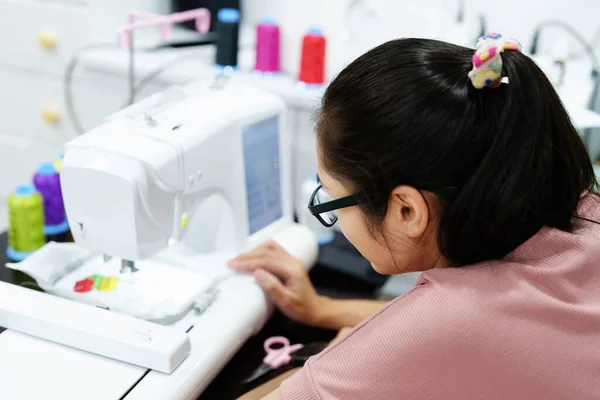 Embroidery, handicrafts, hobbies, SME business, family business, Portrait of Asian female designers are doing by designing patterns using automatic embroidery machines by customer order