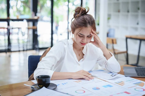 Genç bir çalışanın portresi masa başında çalışırken gergin ve stresli yüzünü gösteriyor..