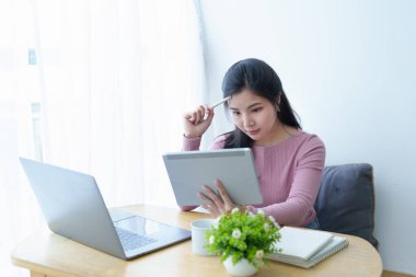Tablet bilgisayar kullanan Asyalı güzel bir kızın portresi..