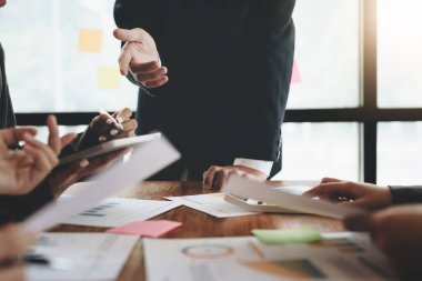 Yatırım risklerini azaltmayı planlayan bir grup iş adamının ortaklarla birlikte çalıştığı imajı, toplantılarda kârlı ve hedeflenmiş müşteri ihtiyaçlarını analiz etmek üzere pazarlama stratejilerini ayarlıyor.