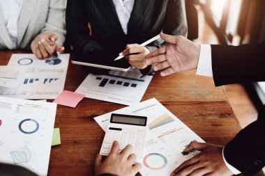 Yatırım risklerini azaltmayı planlayan bir grup iş adamının ortaklarla birlikte çalıştığı imajı, toplantılarda kârlı ve hedeflenmiş müşteri ihtiyaçlarını analiz etmek üzere pazarlama stratejilerini ayarlıyor.