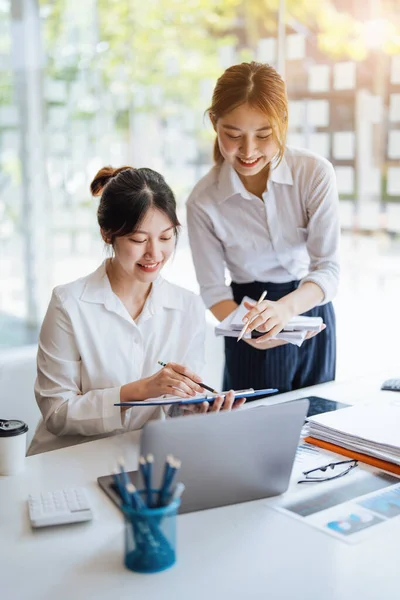 Negotiation, Analysis, Discussion: Portrait of an Asian woman economist and marketer pointing to a financial data sheet to plan investments to prevent risks and losses for the company.