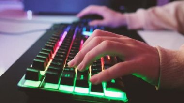 Oyuncu elleri, oyuncu elleri RGB klavyesinde, profesyonel siber oyun oyuncularının RGB klavyesiyle yakın çekimleri. Havalı neon ışıkları olan bir arka plan. Oyuncuların ellerinin 4k görüntüsü.