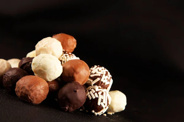 Chocolate candy pyramid, concept idea photo of chocolate candy pyramid with black background with copy space area. Beautiful, tasty handmade pralines isolated on black close up photo.