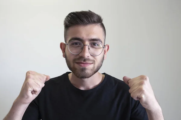 Teenager in winner position,  portrait of caucasian handsome teenager in winner position clenched fists. Brown haired generation z teenage boy celebrating a victory, excited in a happy winner pose.