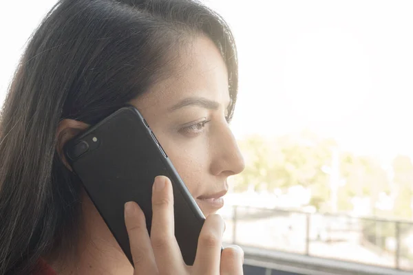 Serious business woman, young millennial caucasian serious business woman listening on the phone. Holding mobile phone, makes business call, feels displeased. Workplace business problems concept.