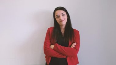 Kendine güvenen bir iş kadını, kendinden emin bir iş kadınının portresi. Kafkasyalı, genç, çekici, esmer kadın kameraya bakıyor, içtenlikle gülümsüyor. Kollarını bağlayan kırmızı klas bir ceket giyiyordu..