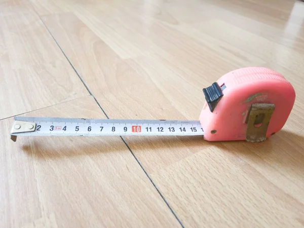 木制背景下的现代磁带测量工具 — 图库照片