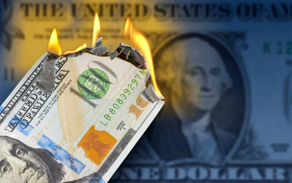 A burning 100 US dollar bill in front of One Dollar banknote
